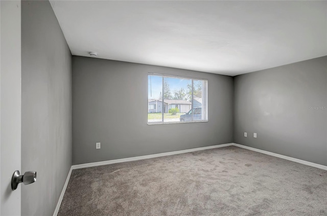 carpeted empty room with baseboards