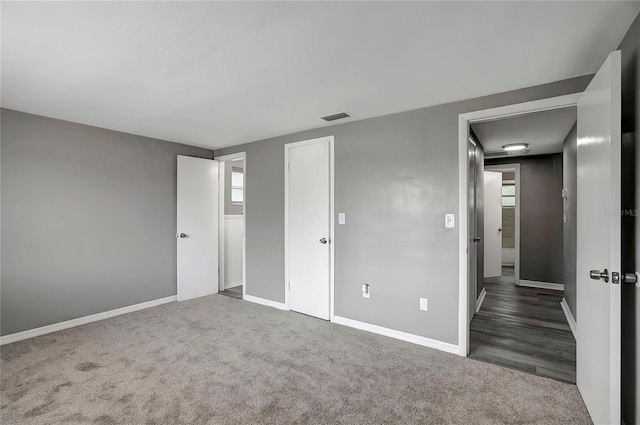 unfurnished bedroom with baseboards, carpet flooring, and visible vents