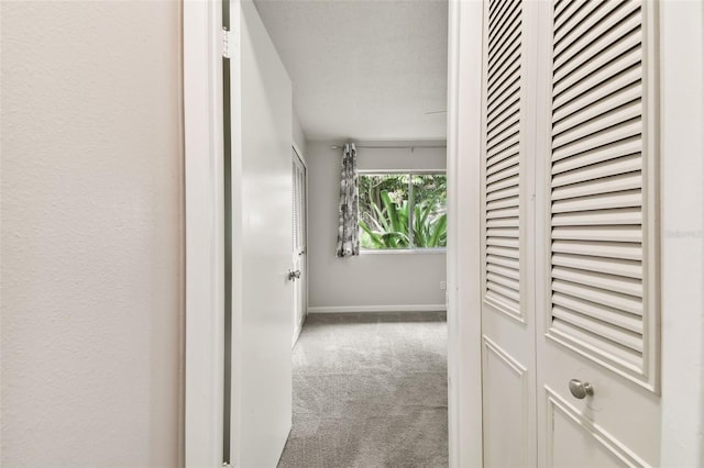 corridor featuring carpet and baseboards
