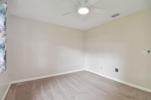 carpeted empty room with baseboards, ceiling fan, and visible vents