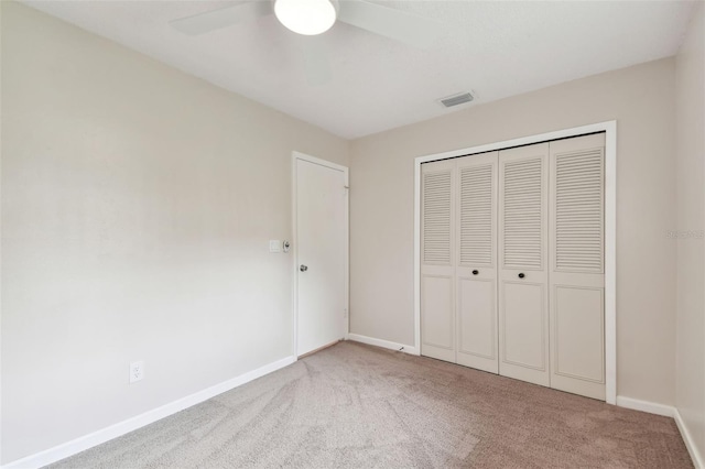unfurnished bedroom featuring a closet, carpet flooring, baseboards, visible vents, and ceiling fan