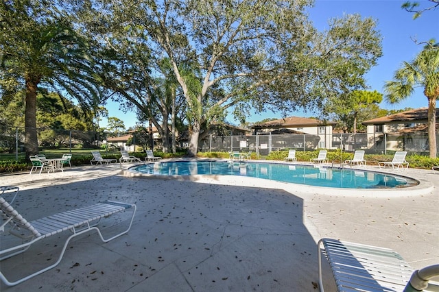 community pool featuring fence and a patio