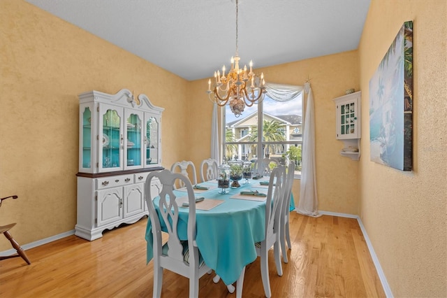 2050 N Pointe Alexis Dr, Tarpon Springs, FL 34689 - dining space featuring an inviting chandelier, baseboards, and light wood-type flooring