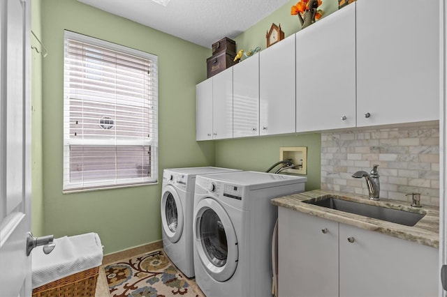 2050 N Pointe Alexis Dr, Tarpon Springs, FL 34689 - clothes washing area with a textured ceiling, baseboards, washing machine and dryer, a sink, and cabinet space