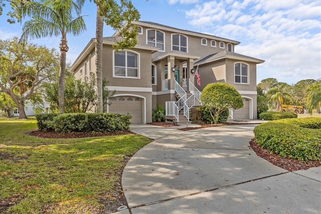 2050 N Pointe Alexis Dr, Tarpon Springs, FL 34689 - view of front of house with stairs, driveway, a front yard, stucco siding, and a garage