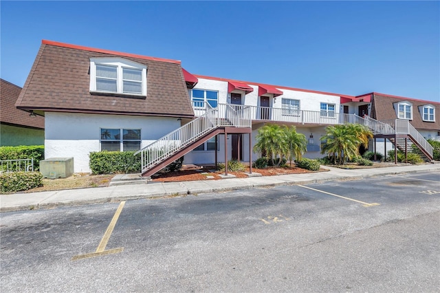 9105 W Hillsborough Ave Unit I102, Tampa, FL 33615 - view of property featuring uncovered parking and stairway