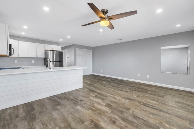 9105 W Hillsborough Ave Unit I102, Tampa, FL 33615 - kitchen with light countertops, a ceiling fan, freestanding refrigerator, a peninsula, and dark wood-style flooring