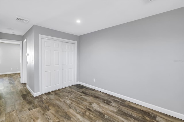 9105 W Hillsborough Ave Unit I102, Tampa, FL 33615 - unfurnished bedroom featuring a closet, dark wood-style floors, baseboards, and visible vents