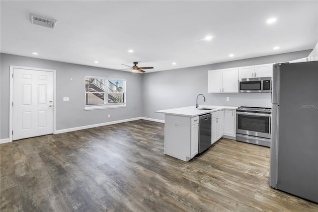 9105 W Hillsborough Ave Unit I102, Tampa, FL 33615 - kitchen with stainless steel appliances, a sink, visible vents, white cabinets, and a peninsula