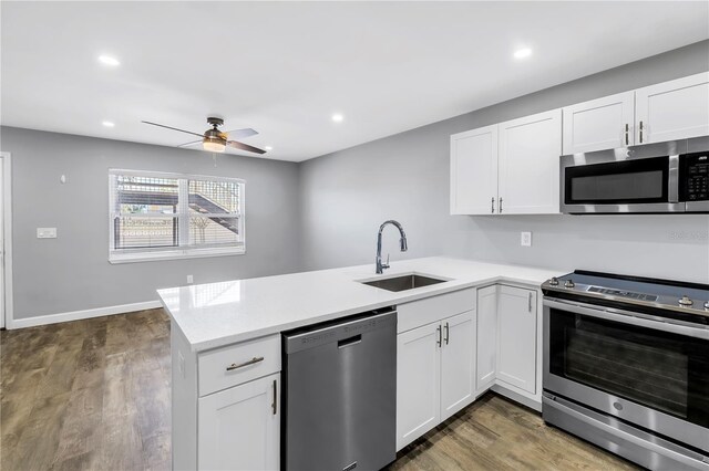 9105 W Hillsborough Ave Unit I102, Tampa, FL 33615 - kitchen with light countertops, stainless steel appliances, a sink, a ceiling fan, and a peninsula