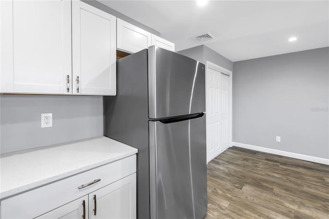 9105 W Hillsborough Ave Unit I102, Tampa, FL 33615 - kitchen featuring visible vents, baseboards, wood finished floors, white cabinetry, and freestanding refrigerator