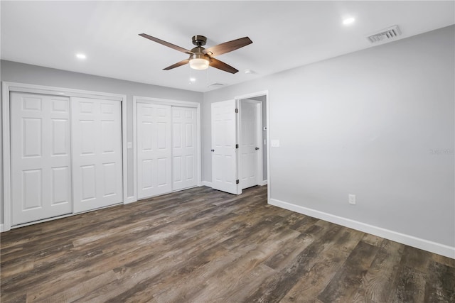 9105 W Hillsborough Ave Unit I102, Tampa, FL 33615 - unfurnished bedroom with multiple closets, dark wood-style flooring, visible vents, baseboards, and recessed lighting