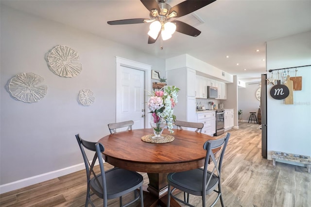8326 Archwood Cir, Tampa, FL 33615 - dining room featuring baseboards, light wood-type flooring, and a ceiling fan