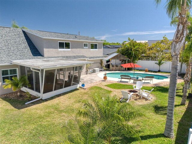 8326 Archwood Cir, Tampa, FL 33615 - view of pool featuring a sunroom, a patio, a fenced backyard, an outdoor fire pit, and a yard