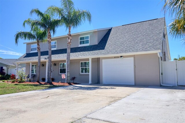 8326 Archwood Cir, Tampa, FL 33615 - view of front of property featuring driveway, an attached garage, brick siding, and roof with shingles