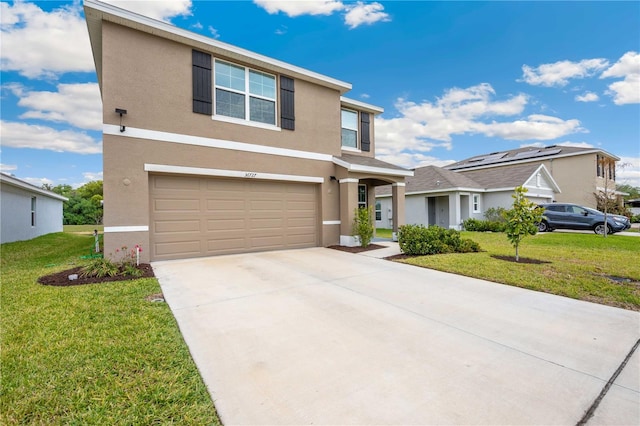 traditional-style house with a front yard, an attached garage, stucco siding, and concrete driveway