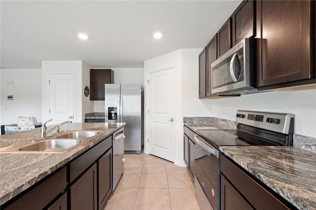 kitchen featuring dark brown cabinets, a sink, stainless steel appliances, and light tile patterned floors