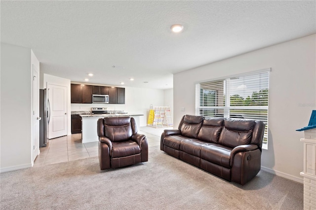 living area with light colored carpet, recessed lighting, baseboards, a textured ceiling, and light tile patterned flooring