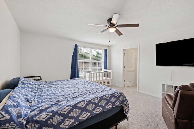 bedroom with carpet floors, baseboards, ceiling fan, and a textured ceiling