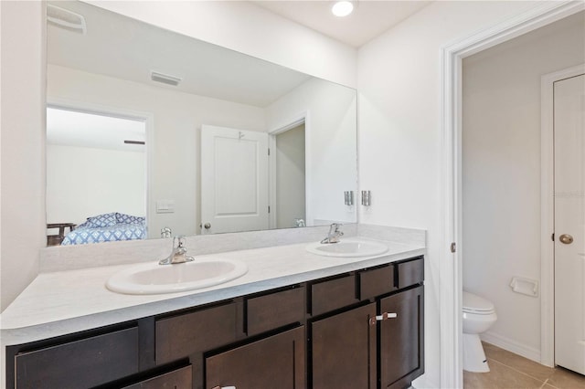 bathroom featuring double vanity, visible vents, toilet, and a sink