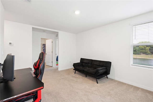 home office with baseboards and light colored carpet