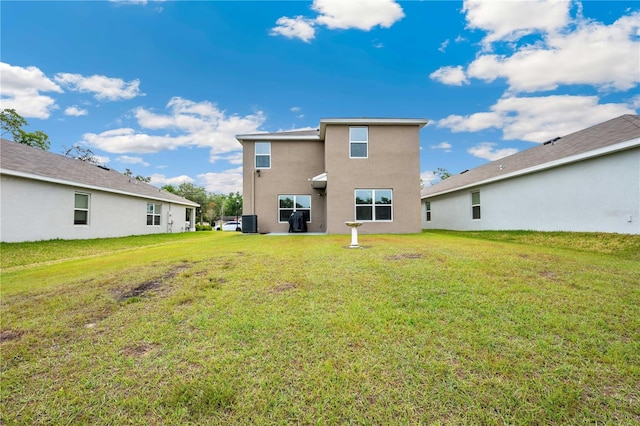 back of house with a lawn, central AC unit, and stucco siding