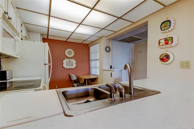 14130 Rosemary Ln Unit 3312, Largo, FL 33774 - kitchen with light countertops, a drop ceiling, a sink, white cabinets, and white microwave