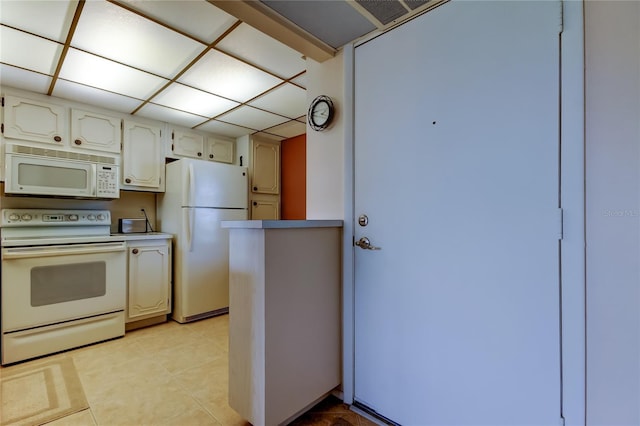 14130 Rosemary Ln Unit 3312, Largo, FL 33774 - kitchen featuring light tile patterned flooring, white appliances, white cabinets, and a paneled ceiling