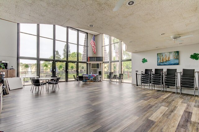 14130 Rosemary Ln Unit 3312, Largo, FL 33774 - interior space featuring expansive windows, a textured ceiling, a towering ceiling, a ceiling fan, and wood finished floors