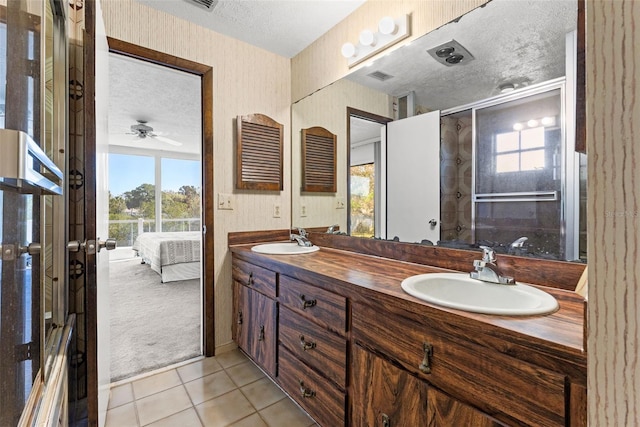 7049 Peninsular Dr, New Port Richey, FL 34652 - ensuite bathroom with a textured ceiling, double vanity, healthy amount of natural light, tile patterned floors, and ceiling fan