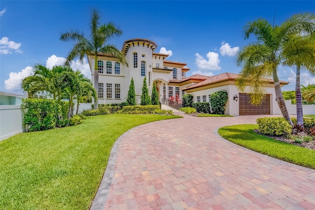362 41st Ave, St Pete Beach, FL 33706 - mediterranean / spanish home featuring a front yard, curved driveway, stucco siding, a tiled roof, and a garage