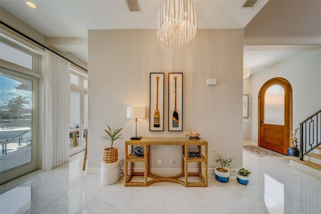 362 41st Ave, St Pete Beach, FL 33706 - hall with stairs, a chandelier, marble finish floor, arched walkways, and visible vents