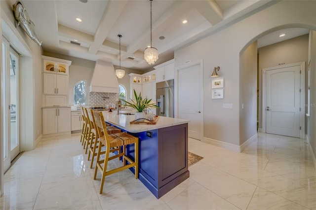 362 41st Ave, St Pete Beach, FL 33706 - kitchen with coffered ceiling, built in refrigerator, a center island with sink, arched walkways, and custom exhaust hood