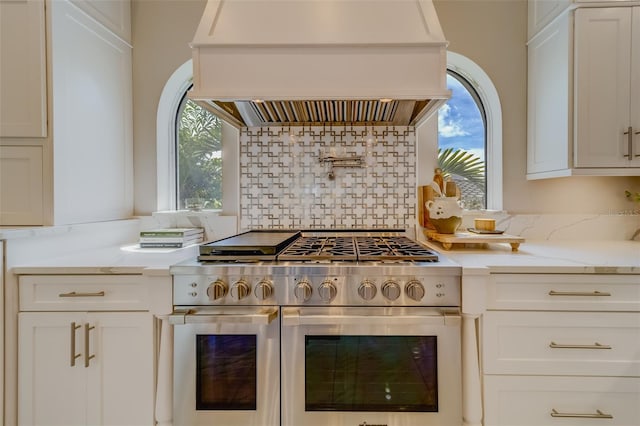 362 41st Ave, St Pete Beach, FL 33706 - kitchen featuring white cabinets, island range hood, plenty of natural light, and double oven range
