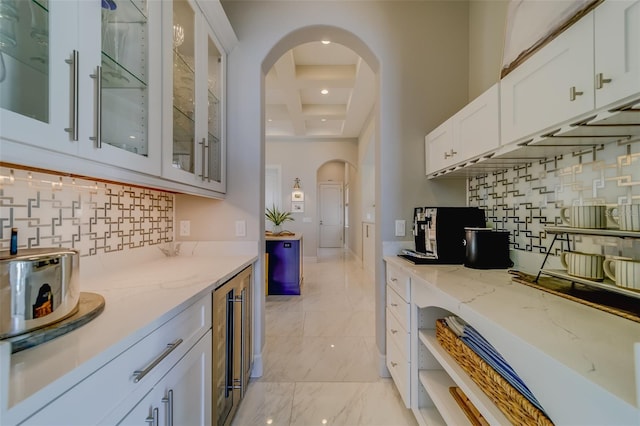 362 41st Ave, St Pete Beach, FL 33706 - kitchen featuring marble finish floor, light stone countertops, arched walkways, glass insert cabinets, and beverage cooler