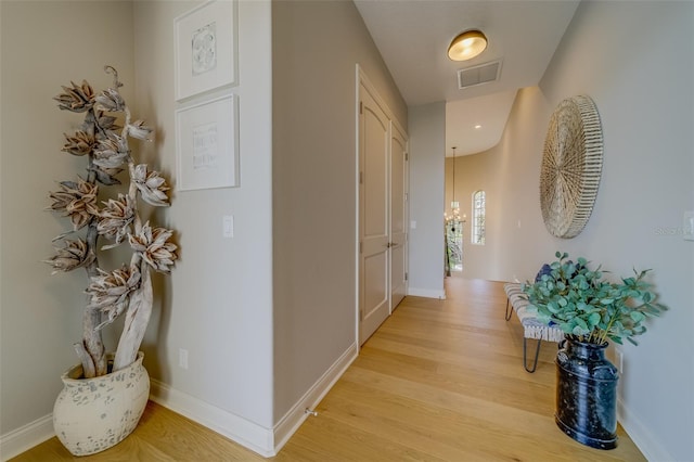 362 41st Ave, St Pete Beach, FL 33706 - hallway with baseboards, visible vents, a chandelier, and light wood finished floors