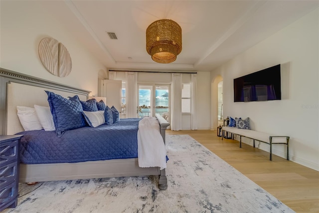 362 41st Ave, St Pete Beach, FL 33706 - bedroom with access to outside, a raised ceiling, arched walkways, visible vents, and wood finished floors