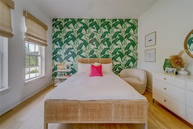362 41st Ave, St Pete Beach, FL 33706 - bedroom featuring wallpapered walls, light wood-style floors, baseboards, and an accent wall