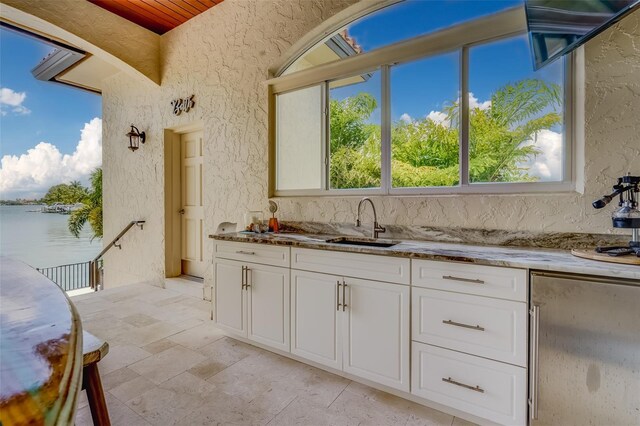 362 41st Ave, St Pete Beach, FL 33706 - kitchen featuring stone countertops, white cabinetry, high end fridge, and a sink
