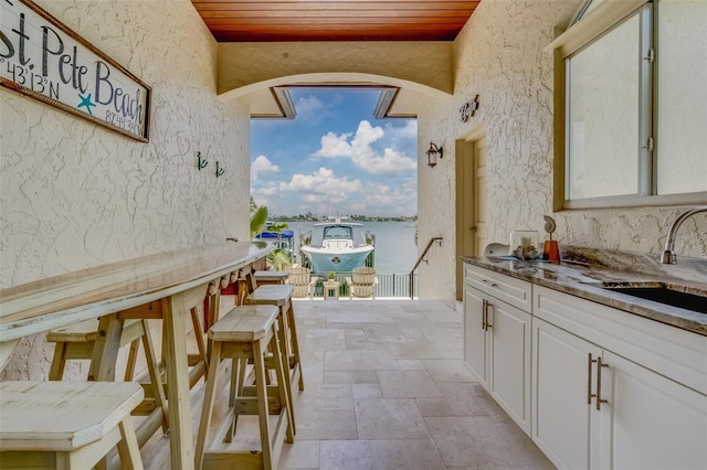 362 41st Ave, St Pete Beach, FL 33706 - view of patio / terrace featuring a water view, outdoor wet bar, a sink, and exterior kitchen