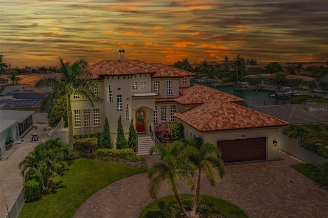 362 41st Ave, St Pete Beach, FL 33706 - mediterranean / spanish house featuring stucco siding, a garage, a tiled roof, and decorative driveway