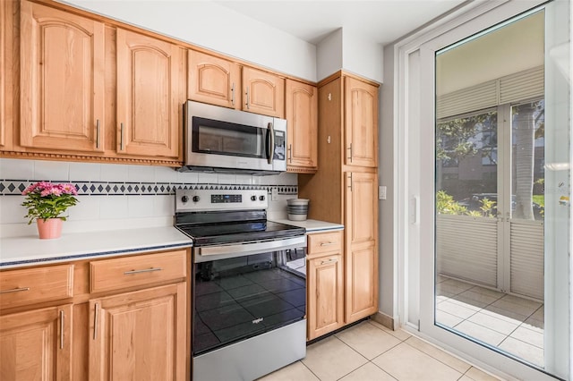 615 10th Ave NE Unit 1, Saint Petersburg, FL 33701 - kitchen featuring light countertops, light tile patterned floors, stainless steel appliances, decorative backsplash, and light brown cabinets