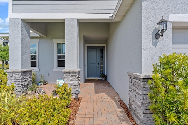 view of exterior entry with stucco siding