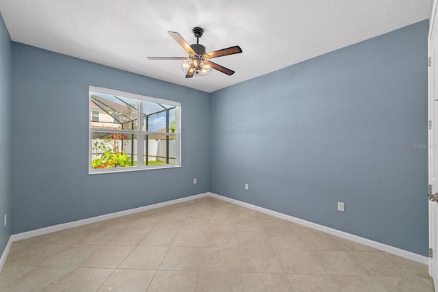empty room with a ceiling fan and baseboards