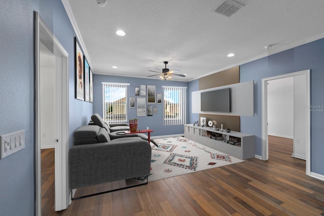 living room featuring a ceiling fan, wood finished floors, a textured ceiling, baseboards, and ornamental molding