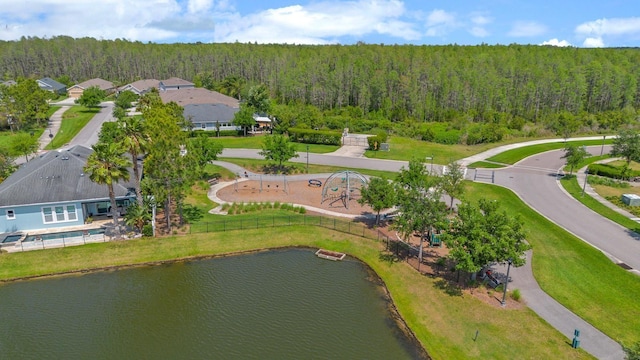 aerial view featuring a wooded view and a water view