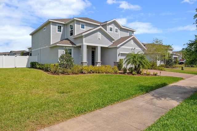 craftsman-style house with a front yard, an attached garage, concrete driveway, and fence