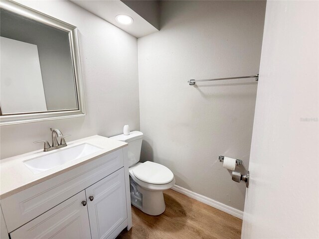 205 Andover Pl N Unit 110, Sun City Center, FL 33573 - bathroom featuring toilet, vanity, wood finished floors, and baseboards