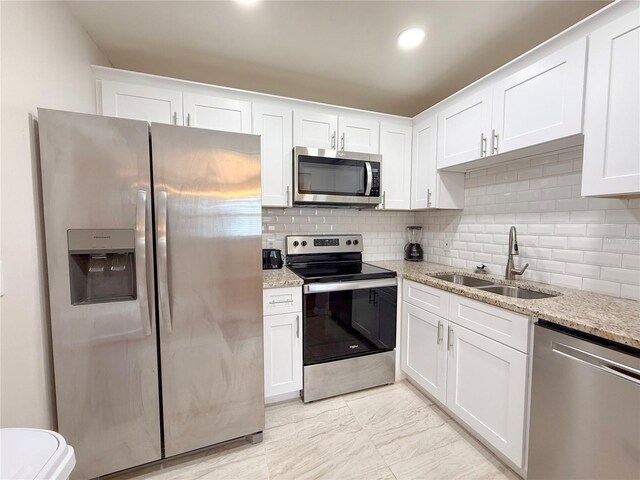 205 Andover Pl N Unit 110, Sun City Center, FL 33573 - kitchen with appliances with stainless steel finishes, a sink, white cabinetry, light stone countertops, and recessed lighting