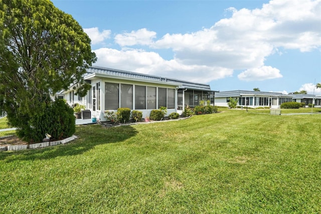 205 Andover Pl N Unit 110, Sun City Center, FL 33573 - rear view of house with a sunroom and a lawn
